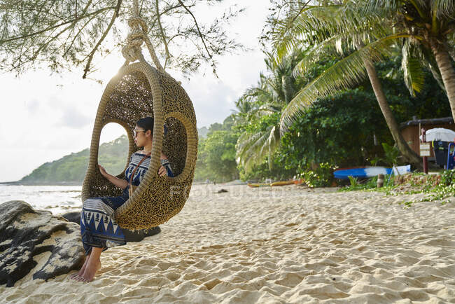 Libera la mujer joven sentada junto a la playa en Koh Kood, Tailandia - foto de stock