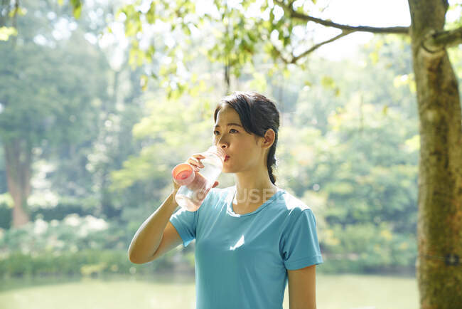 Woman hydrating after working out in Botanic Gardens, SIngapore — Stock Photo