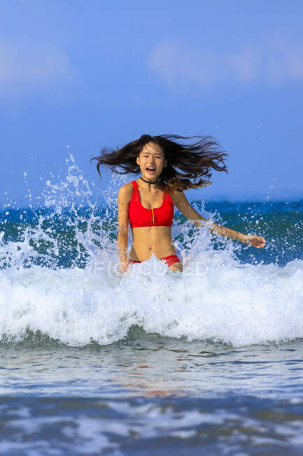 Дві молоді азіатські жінки чудово проводять час у хвилях океану . — стокове фото