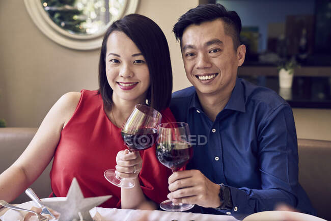 COMMUNIQUÉS Joyeux jeune couple asiatique célébrant Noël ensemble — Photo de stock