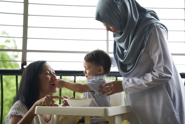 Nonna e madre legano con il bambino sul balcone — Foto stock