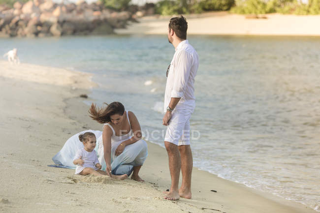 Heureux jeune famille passer du temps ensemble sur la plage — Photo de stock