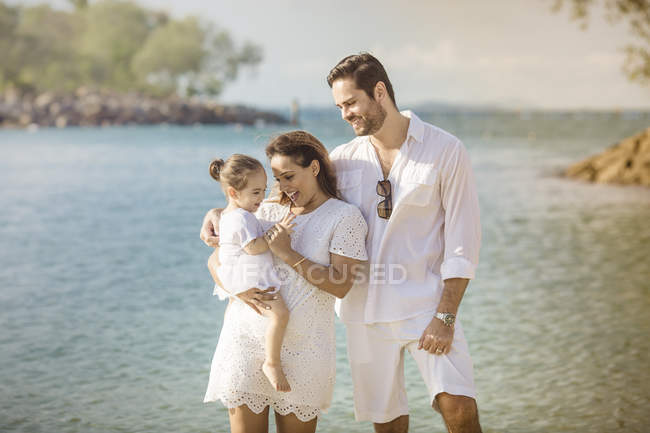 Heureux jeune famille passer du temps ensemble sur la plage — Photo de stock