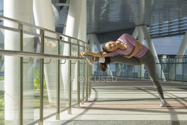 Молодая азиатка растягивается перед ежедневной тренировкой в Сингапоре . — стоковое фото