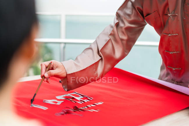 Cropped image of male hand drawing calligraphy hieroglyphs — Stock Photo