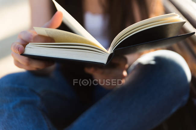 Обрізаний образ молодої жінки читає книгу, крупним планом — стокове фото