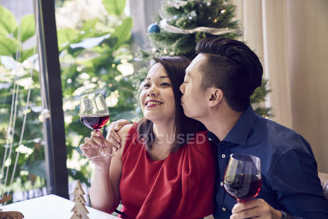 Happy asian couple with wine celebrating christmas — Stock Photo