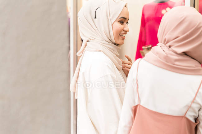 Dos amigos musulmanes frente a la tienda conversando - foto de stock