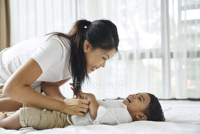 Ásia mãe ligação com ela filho no o cama — Fotografia de Stock