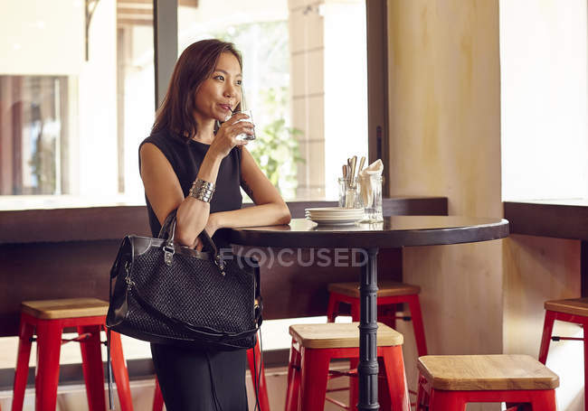 Красива молода жінка п'є алкоголь в розкішному кафе — стокове фото