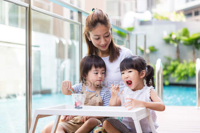 Woman enjoying a healthy snack time with her children. — Stock Photo