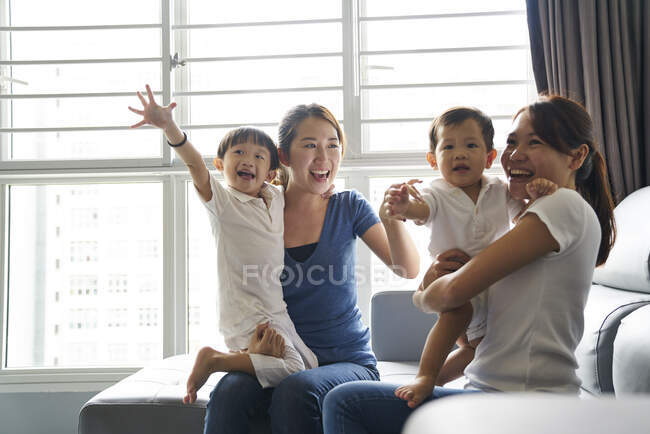 Релаксація Молоді мами зв'язуються зі своїми дітьми у вітальні — стокове фото