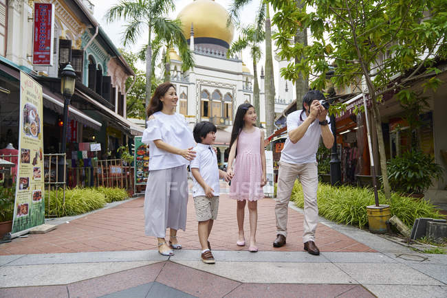 Счастливая молодая азиатская семья вместе путешествует по Арабской улице в Сингапуре — стоковое фото