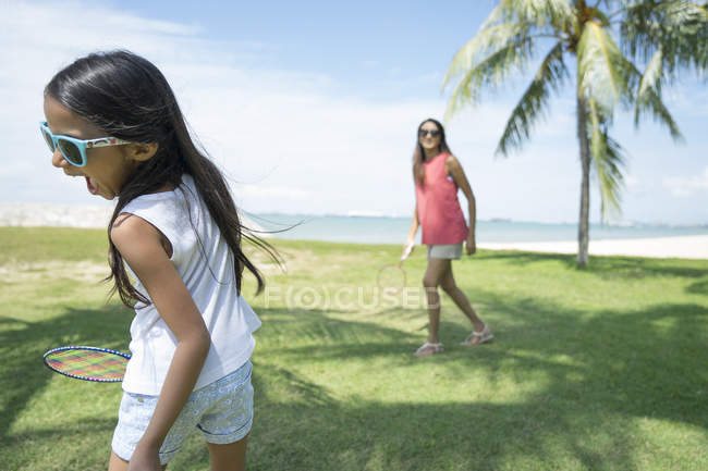 Jovem asiático mãe com bonito filha jogar no badminton ao ar livre — Fotografia de Stock