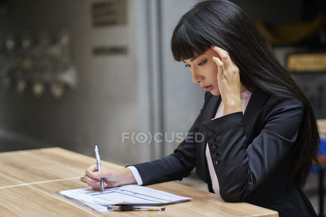 Young attractive asian businesswoman working in cafe — Stock Photo