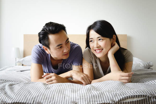 Erwachsene asiatische Paar zusammen liegend im Bett zu Hause — Stockfoto