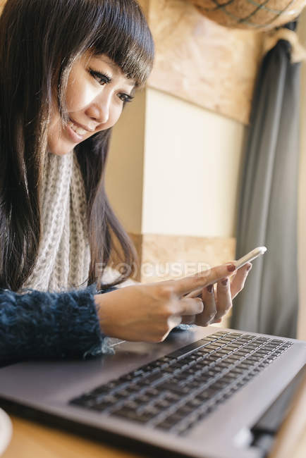 Young attractive asian woman using smartphone — Stock Photo