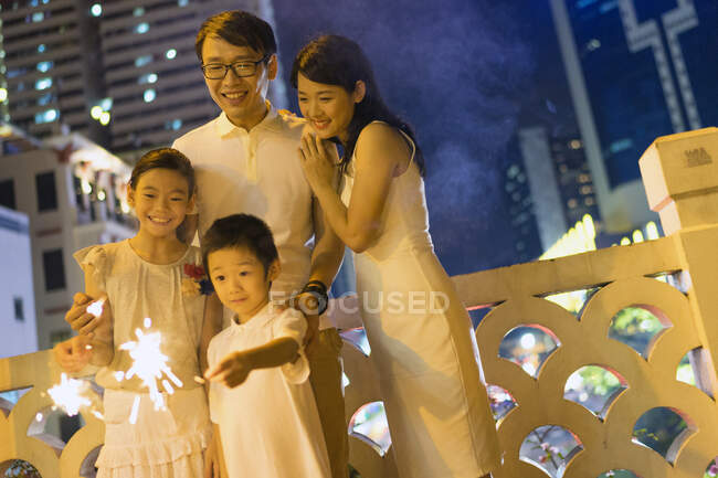 РЕЛИЗ молодую азиатскую семью вместе с бенгальскими огнями на китайский Новый год — стоковое фото