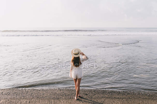 Giovane donna passeggia sulla spiaggia di Bali — Foto stock