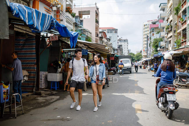 Young asian couple sightseeing in a local market in Ho Chi Minh City, Vietnam. — Stock Photo