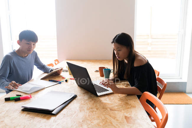 Молоді азіатські люди працюють разом, працюючи разом з ноутбуком в офісі — стокове фото