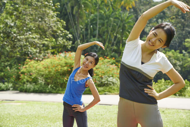 Дві жінки практикують йогу в ботанічних садах (Сінгапур). — стокове фото