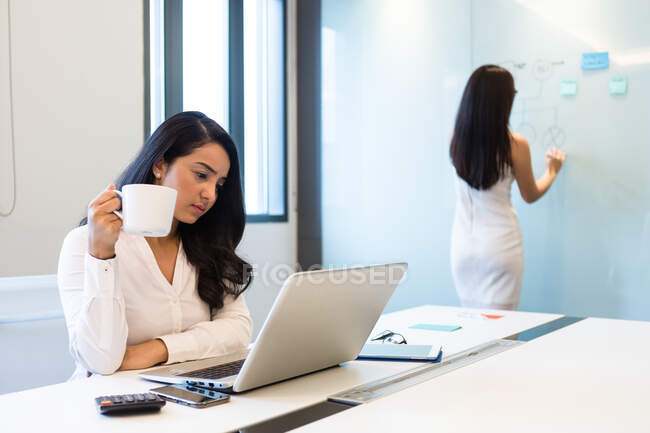 Due giovani donne che lavorano in una sala conferenze. — Foto stock