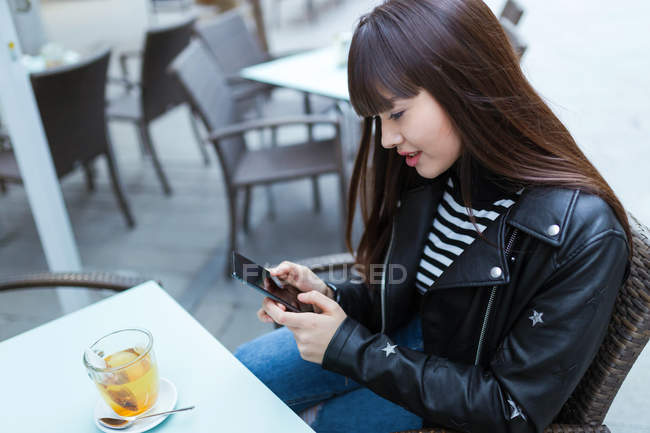 Jovem atraente asiático mulher no cidade usando smartphone — Fotografia de Stock