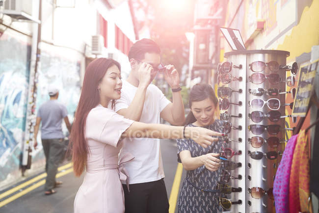 Jeunes amis asiatiques heureux prenant des lunettes passer du temps ensemble à Singapour — Photo de stock