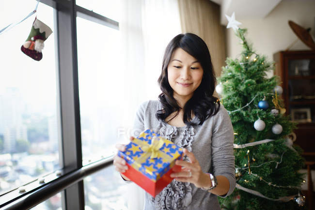 Felice donna asiatica che celebra il Natale a casa — Foto stock