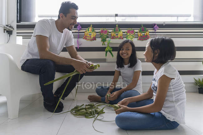 Felice famiglia asiatica che celebra hari raya a casa e prepara decorazioni — Foto stock