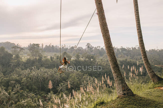 Mulher em um balanço contra uma bela paisagem em Bali — Fotografia de Stock