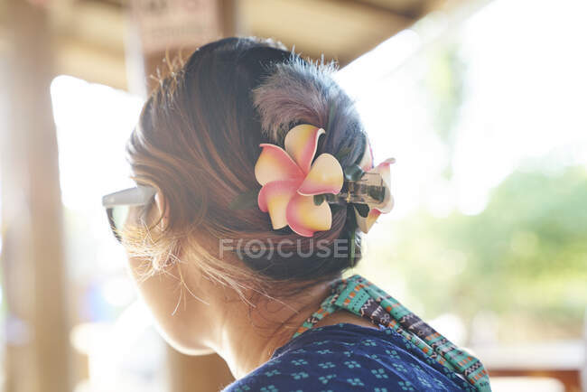 COMUNICATI Veduta posteriore di una giovane donna con fiori tra i capelli — Foto stock