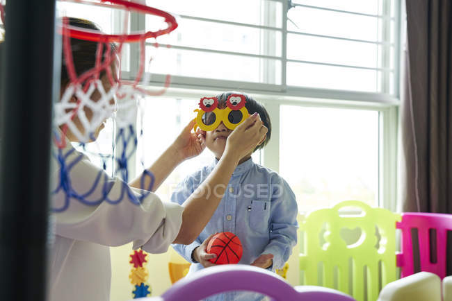 Asian mother and son bonding with fun glasses — Stock Photo