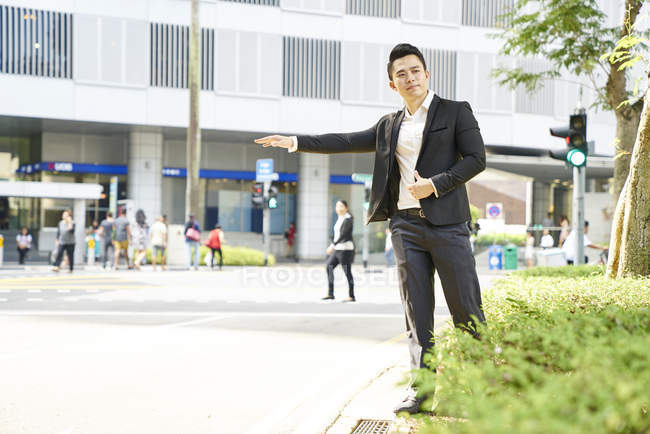 Jeune asiatique succès homme d'affaires attraper taxi — Photo de stock
