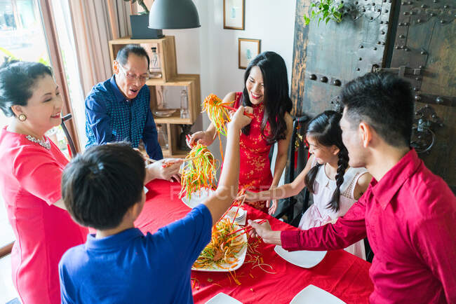RELEASES Glückliche asiatische Familie beim gemeinsamen Essen zu Hause — Stockfoto