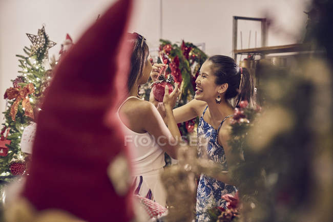 Zwei junge Asiatinnen shoppen zu Weihnachten gemeinsam in Einkaufszentrum — Stockfoto