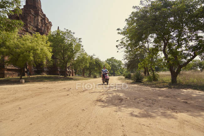 Junger Mann auf einem Motorrad an der Pagode, Myanmar — Stockfoto