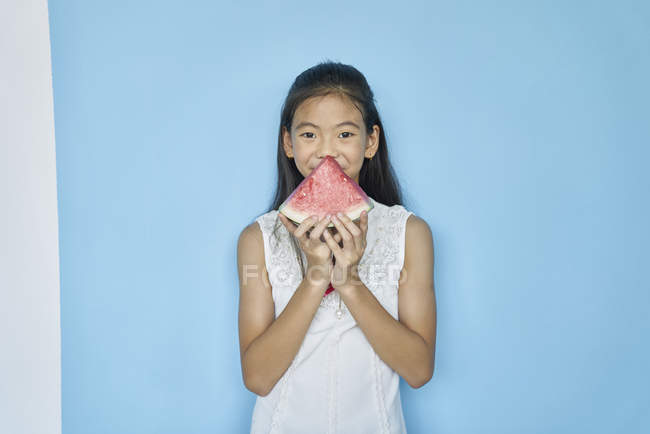 Heureux asiatique girlholding pastèque sur fond bleu — Photo de stock