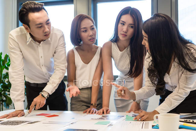 Молодые азиаты, работающие вместе в современном офисе — стоковое фото