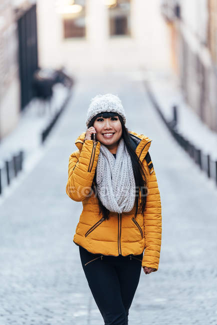 Jeune attrayant asiatique femme en utilisant smartphone sur la rue — Photo de stock