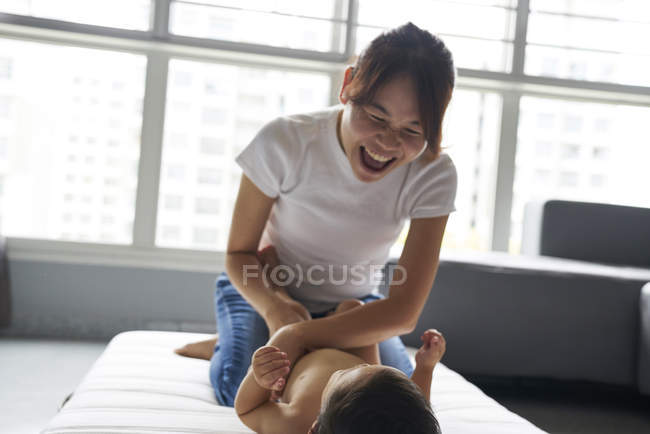 Mãe mudando fraldas para seu adorável menino — Fotografia de Stock