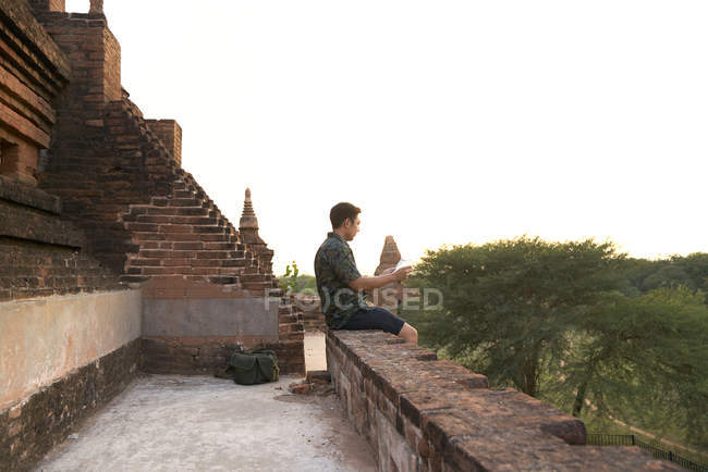 Молодой человек отдыхает в древнем храме Пятадара, Баган, Мьянма — стоковое фото