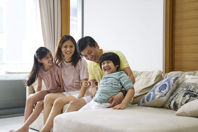 Счастливая молодая азиатская семья вместе веселится дома — стоковое фото