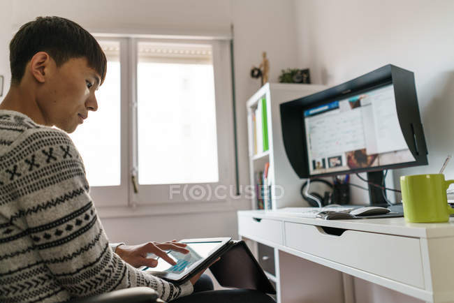 Jovem adulto asiático homem usando digital tablet em casa — Fotografia de Stock
