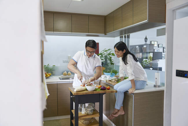 Счастливая молодая азиатская пара готовит вместе — стоковое фото
