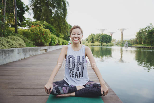 Jovem desportivo asiático mulher fazendo ioga no cais — Fotografia de Stock