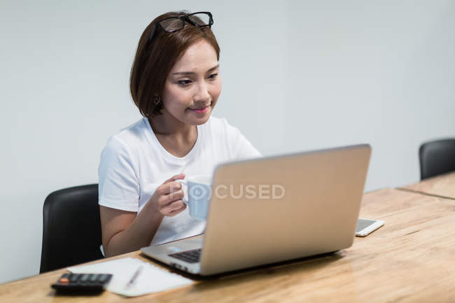 Jovem mulher asiática trabalhando no escritório moderno — Fotografia de Stock