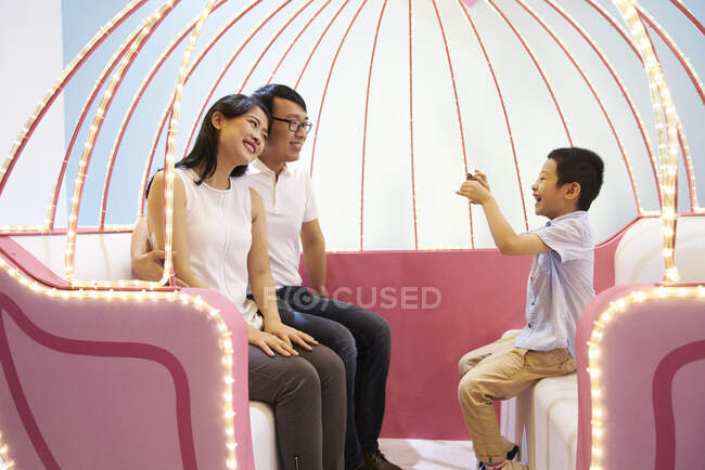 RELEASES Happy young asian family taking photo together — Stock Photo