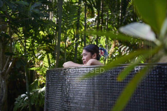 RELEASES Young asian woman relaxing in a pool — Stock Photo